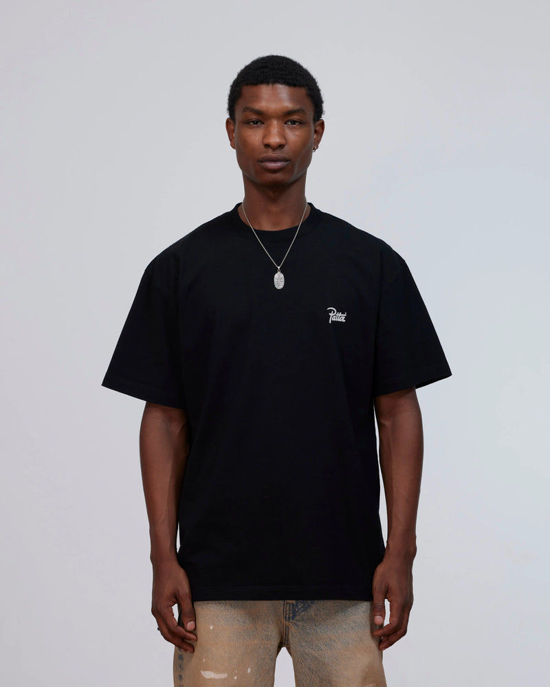 Front view of a model wearing the black Patta Charm cotton t-shirt with script logo on the chest.