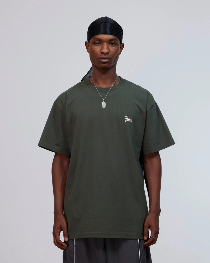Front view of a model wearing the Patta Charm T-Shirt in Climbing Ivy green.