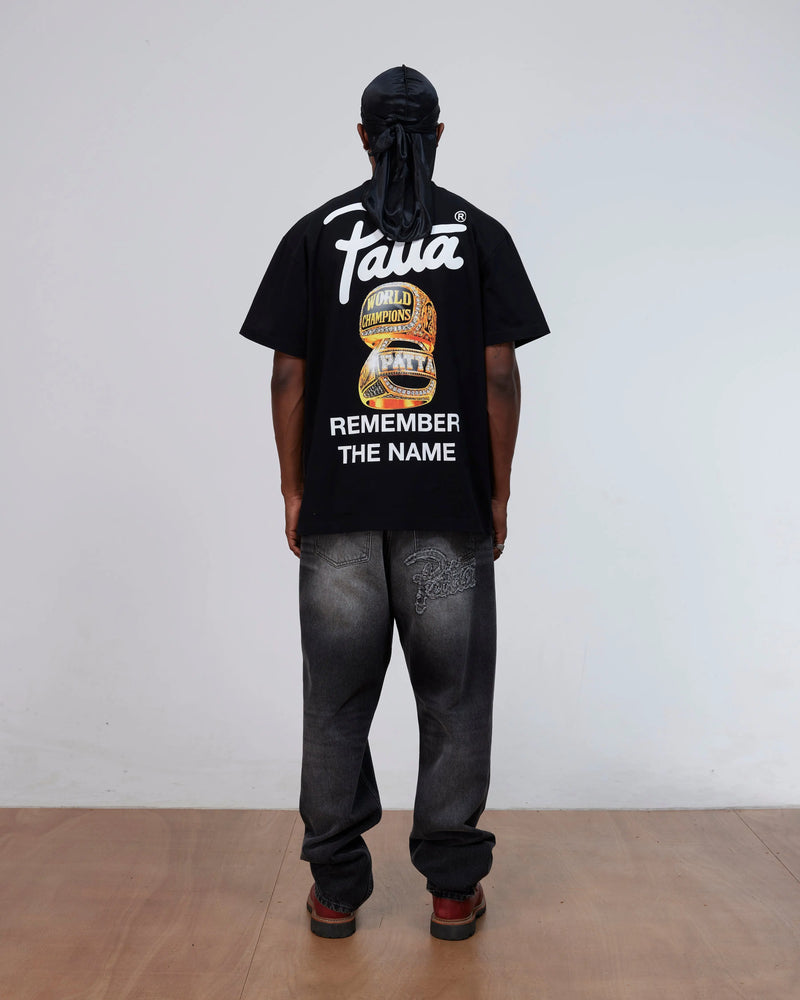 Back view of a model wearing the black Patta Championship T-Shirt with championship rings graphic.