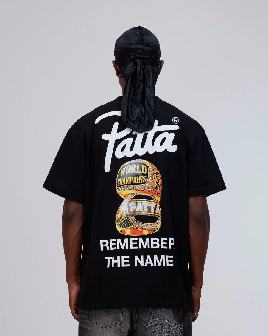 Back view of a model wearing the black cotton Patta Championship T-Shirt with graphic artwork.