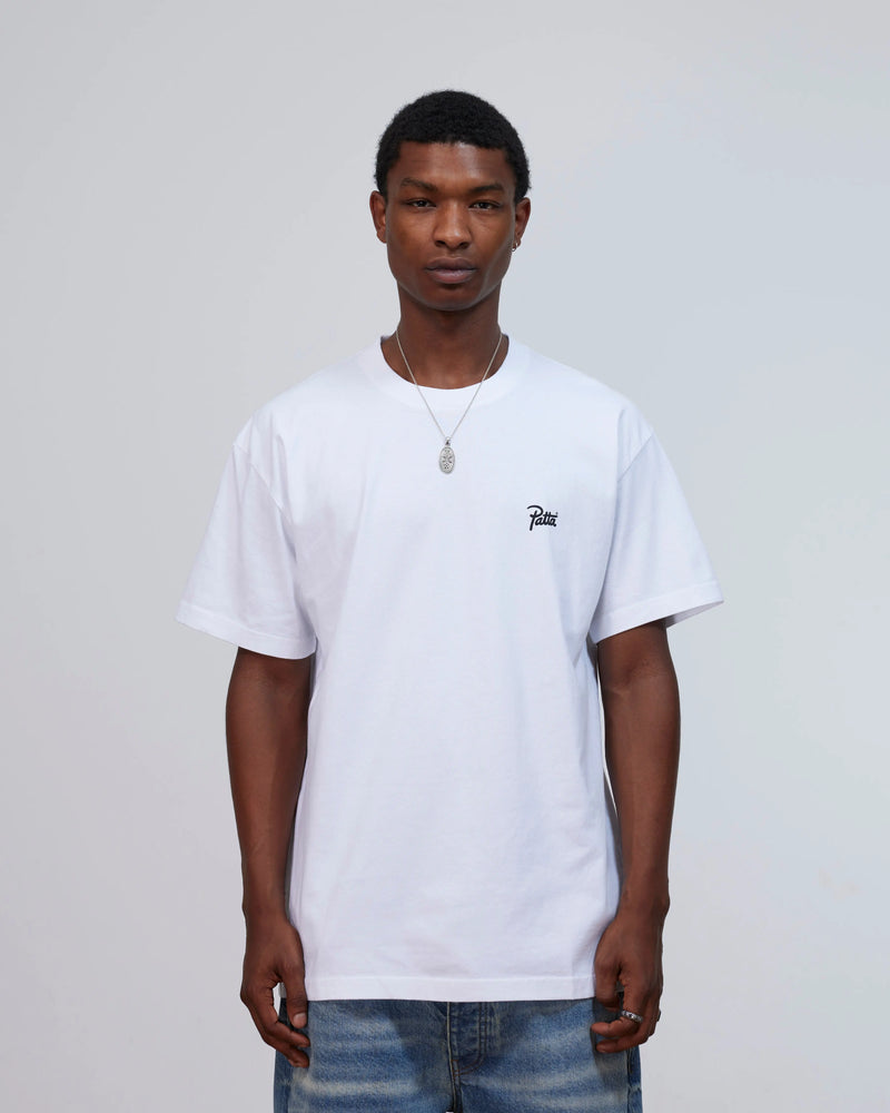 Model wearing the white Patta Championship T-shirt featuring a script logo on the chest.