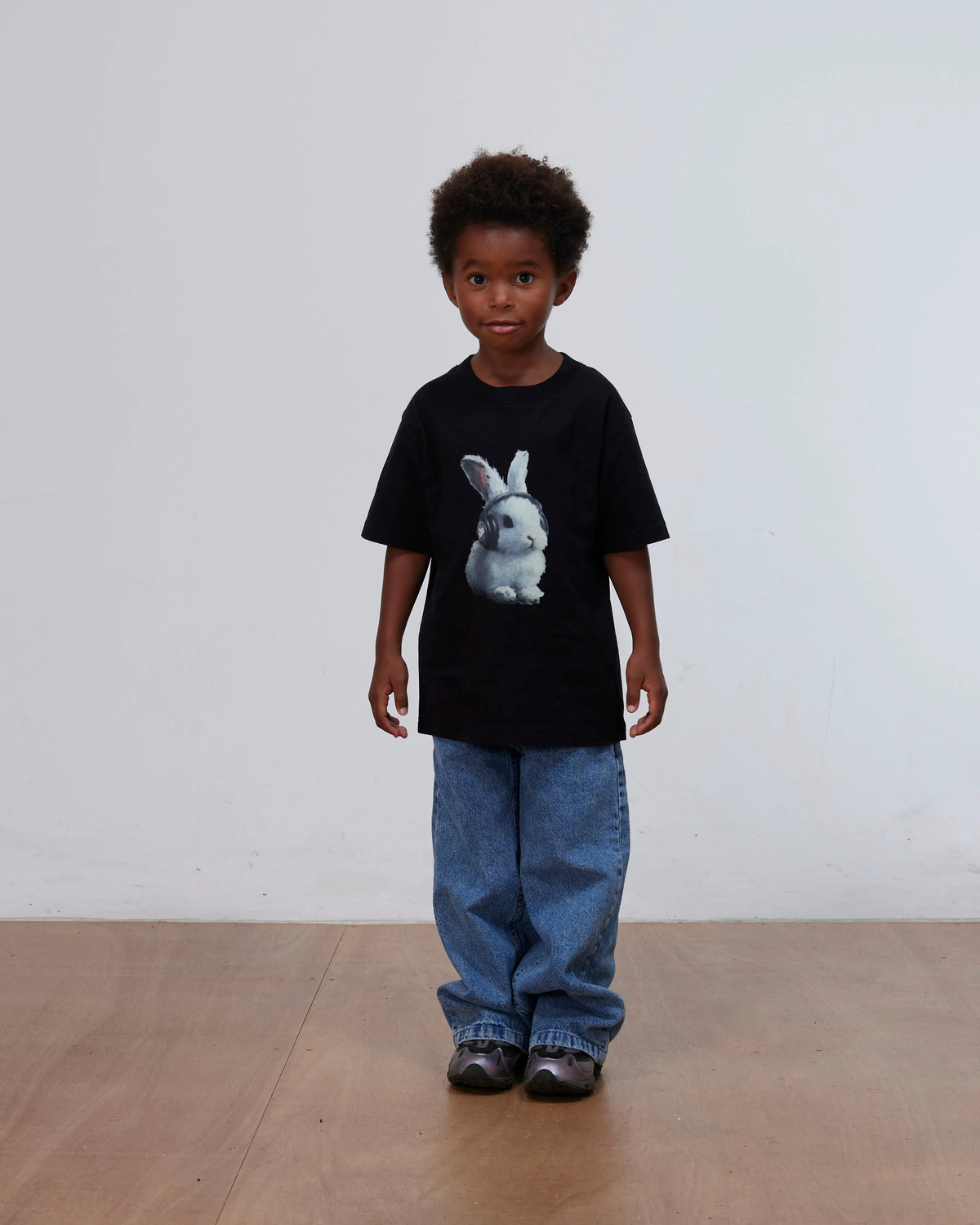 Kid model wearing the black Patta Kids Bunny T-Shirt featuring a bunny graphic.