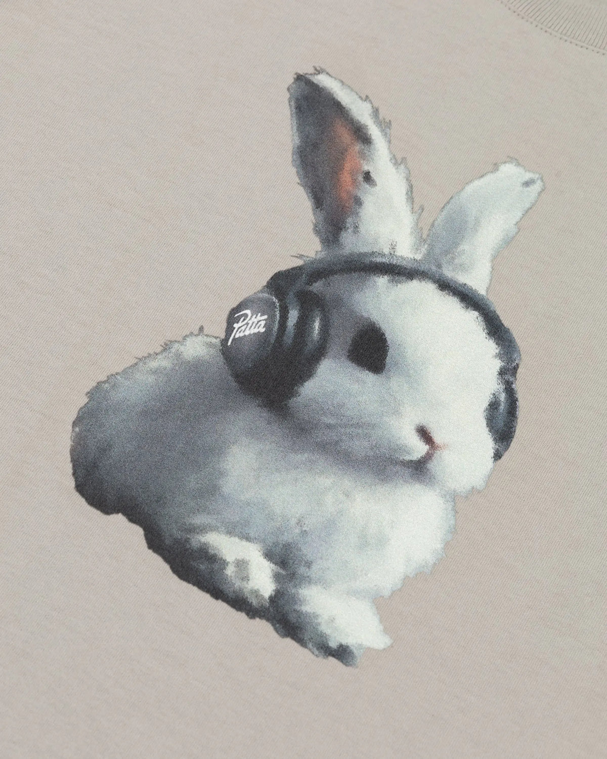 Close-up of bunny wearing Patta branded headphones printed on a flint gray kids cotton t-shirt.