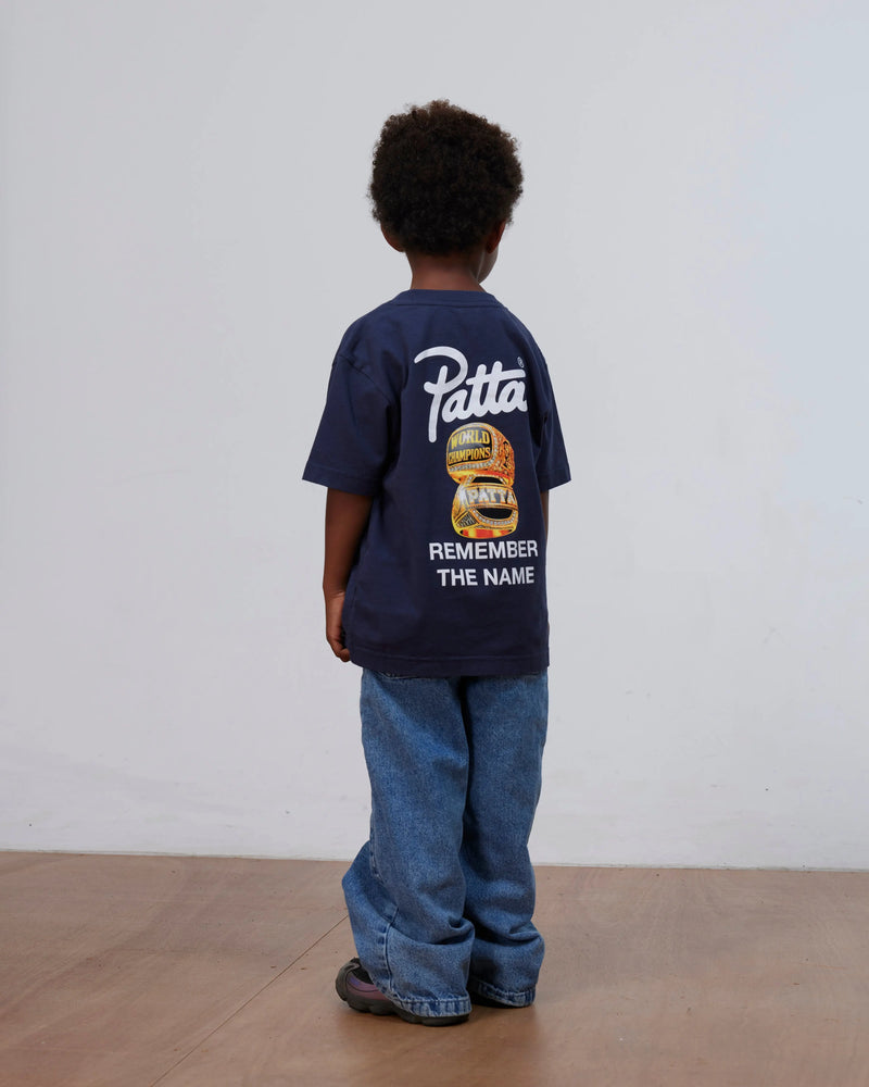 Back view of a child wearing the Patta Kids Championship T-Shirt in black iris with graphic print.