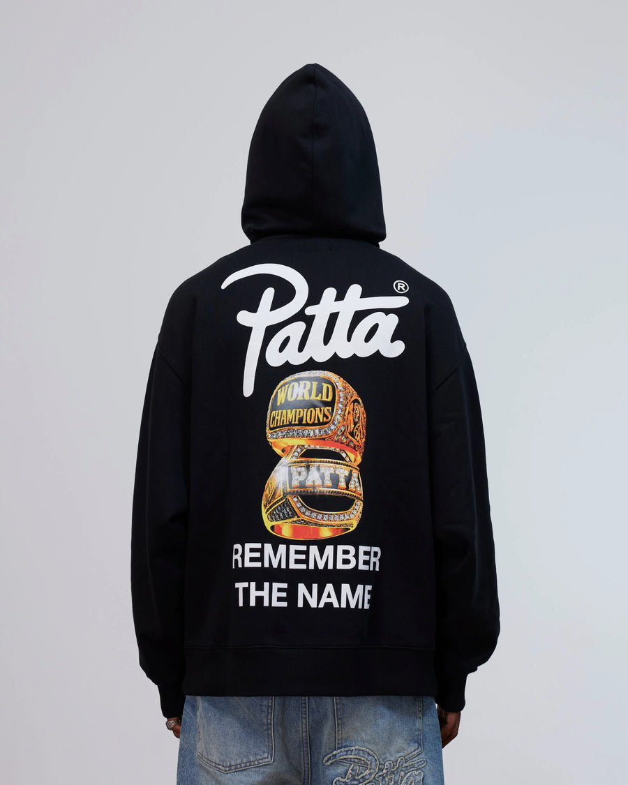 Back view of the Patta Kids Championship Hooded Sweater in black with rings graphic and logo print.