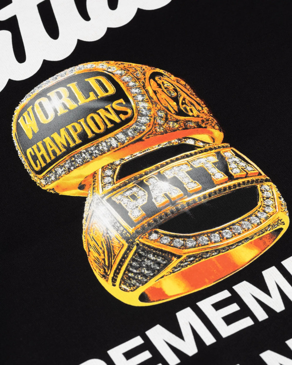 Close-up of the gold championship rings graphic print on the black Patta Championship hooded sweater.