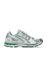 Side profile of the ASICS Gel-Kayano 12.1 sneaker in white and metallic silver with green accents.