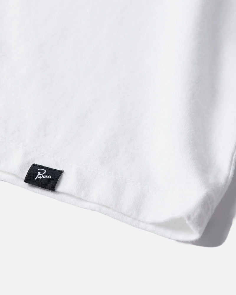Close-up of the woven Parra brand tag on the hem of a white cotton ByParra T-shirt.