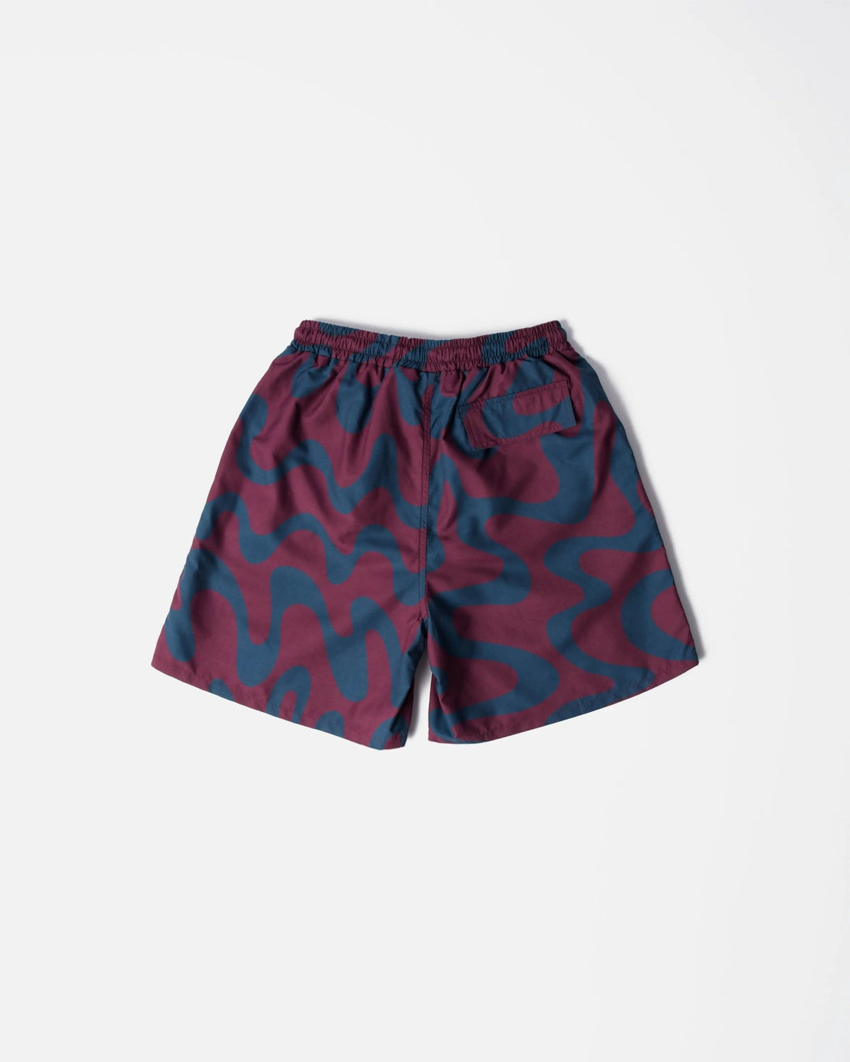 Back view of ByParra Splashed swim shorts in a burgundy and blue wavy print on a white background.