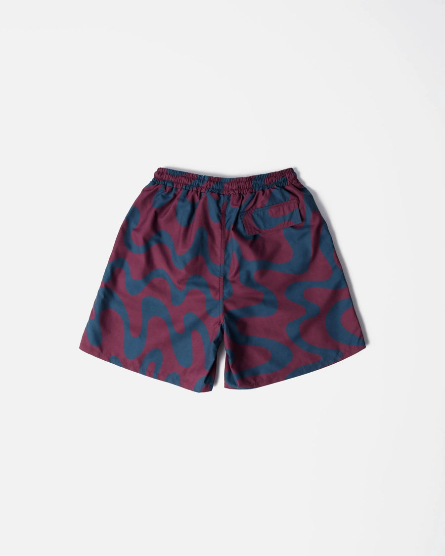 Back view of ByParra Splashed swim shorts in a burgundy and blue wavy print on a white background.