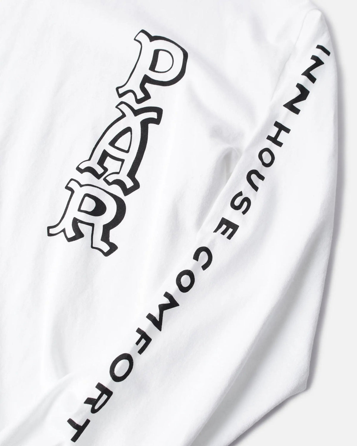 Close-up of graphic lettering on the sleeve of the white ByParra Your Face long-sleeve T-shirt.