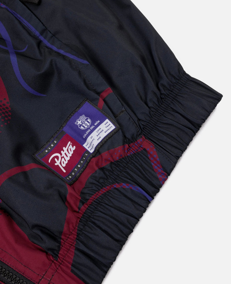 Close-up of the woven Patta and FC Barcelona patch on the elastic hem of the Culers del Món track jacket.