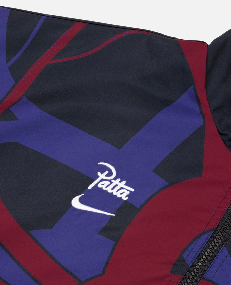 Close-up of embroidered Nike swoosh and Patta logo on the FCB x Patta Culers del Món track jacket.