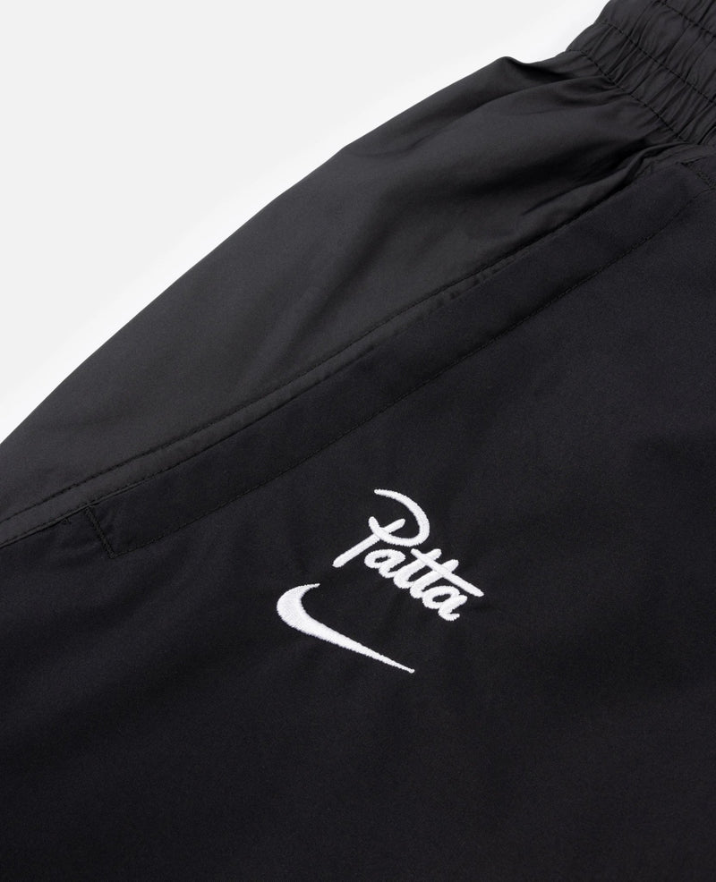 White embroidered Patta logo and Nike swoosh on black FCB x Patta Culers del Món track pants.
