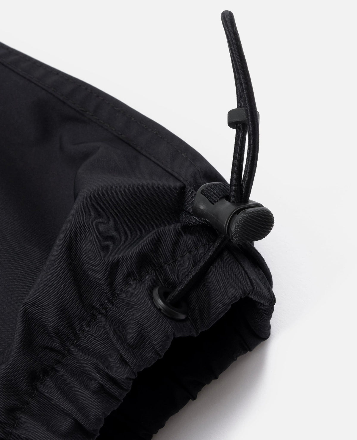 Close-up of the adjustable drawstring hem on the black FCB x Patta Culers del Món Track Pants.