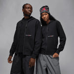 Two models wearing the black Jordan x Awake NY full-zip fleece hoodie with red logo details.