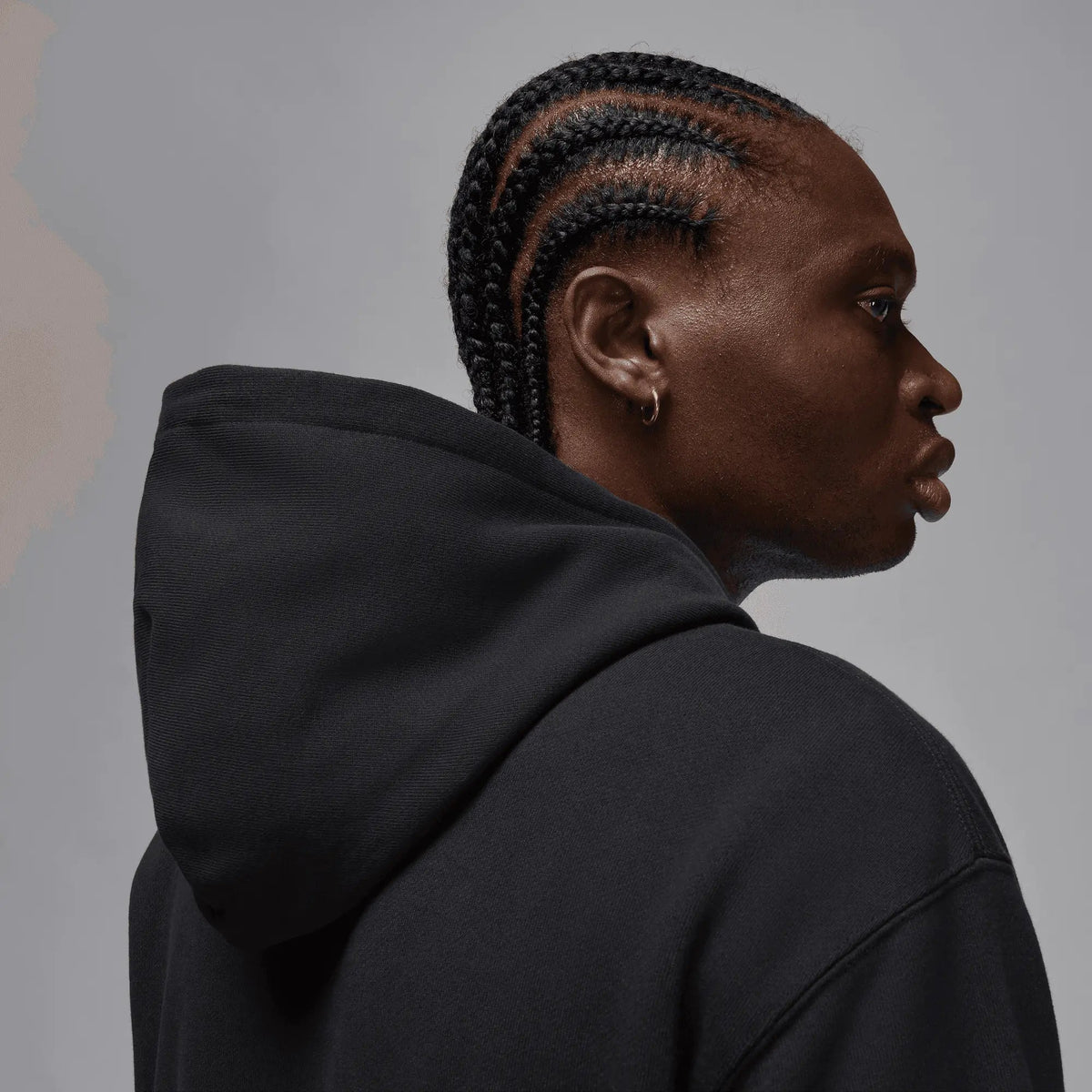 Close-up side view of a model wearing the black Jordan x Awake NY fleece hoodie.