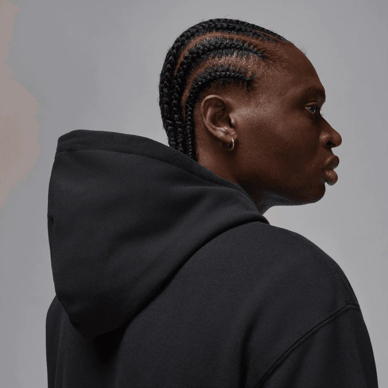 Close-up side view of a model wearing the black Jordan x Awake NY fleece hoodie.