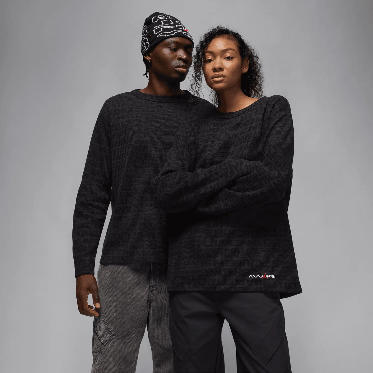 Two models wearing black Jordan x Awake NY waffle-knit long-sleeve thermal shirts.