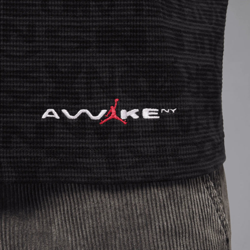 Close-up of the embroidered Awake NY and red Jumpman logo on a black Jordan thermal shirt.