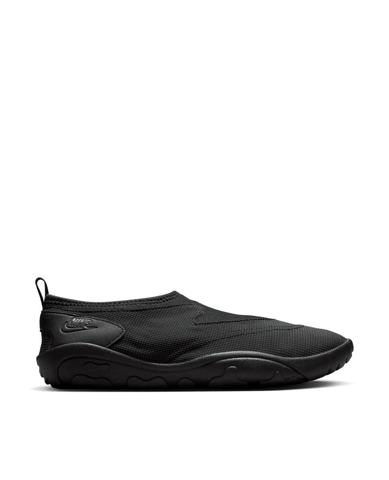 Side view of the all-black Nike Aqua Turf slip-on shoe featuring a textured mesh upper and rubber sole.