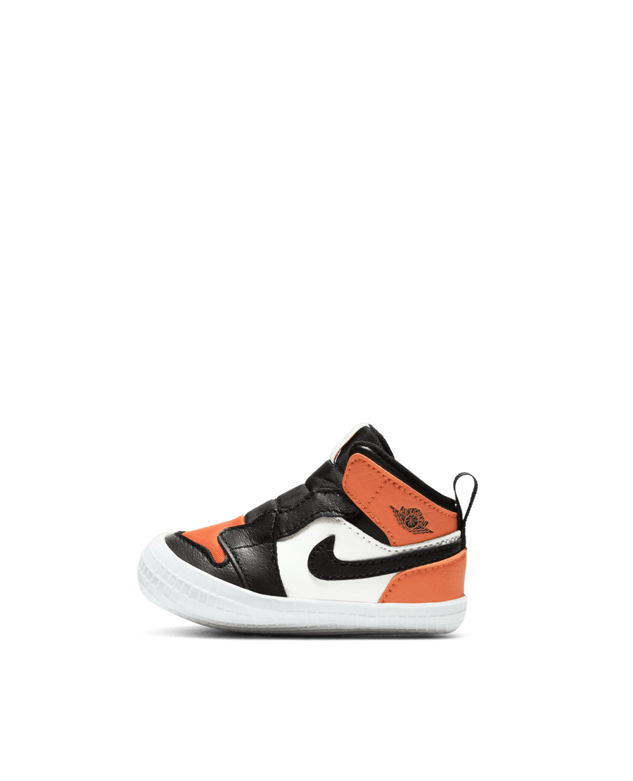Nike Jordan 1 Crib Bootie in Sail, Black, and Starfish orange leather shown in side profile on a black background.