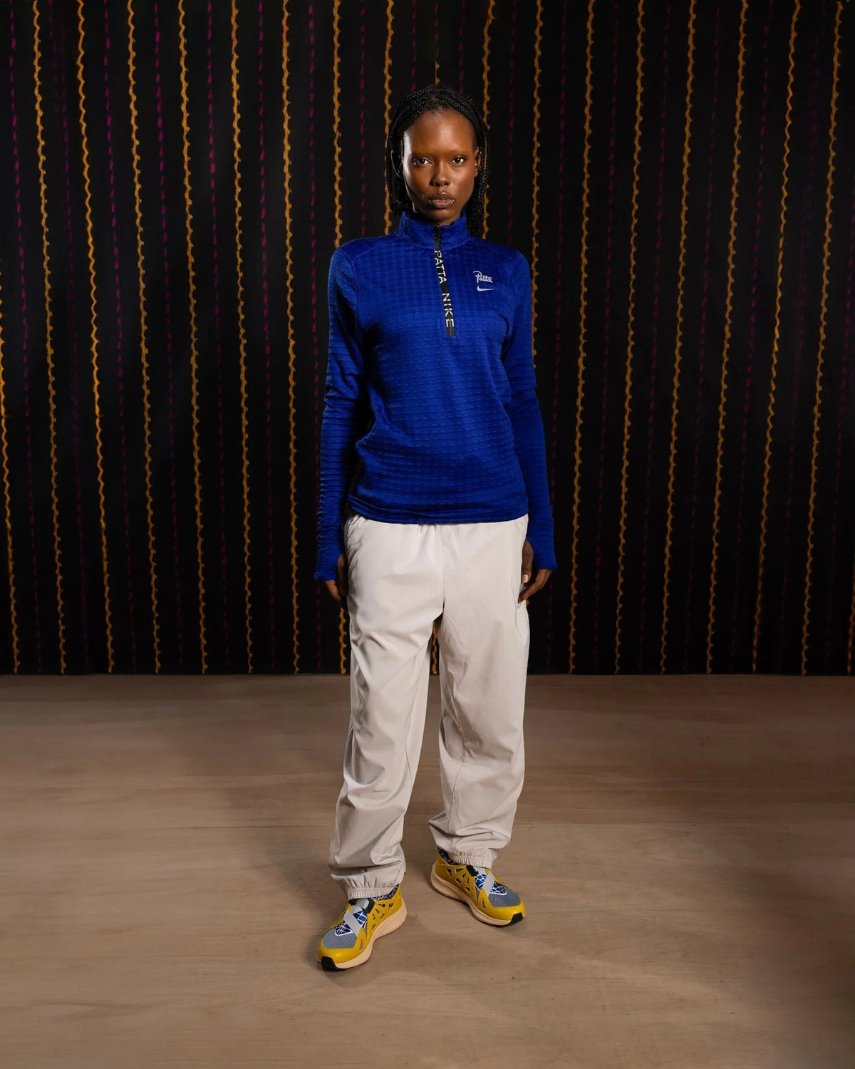 Female model wearing the Nike x Patta Running Team deep royal blue half-zip longsleeve top.