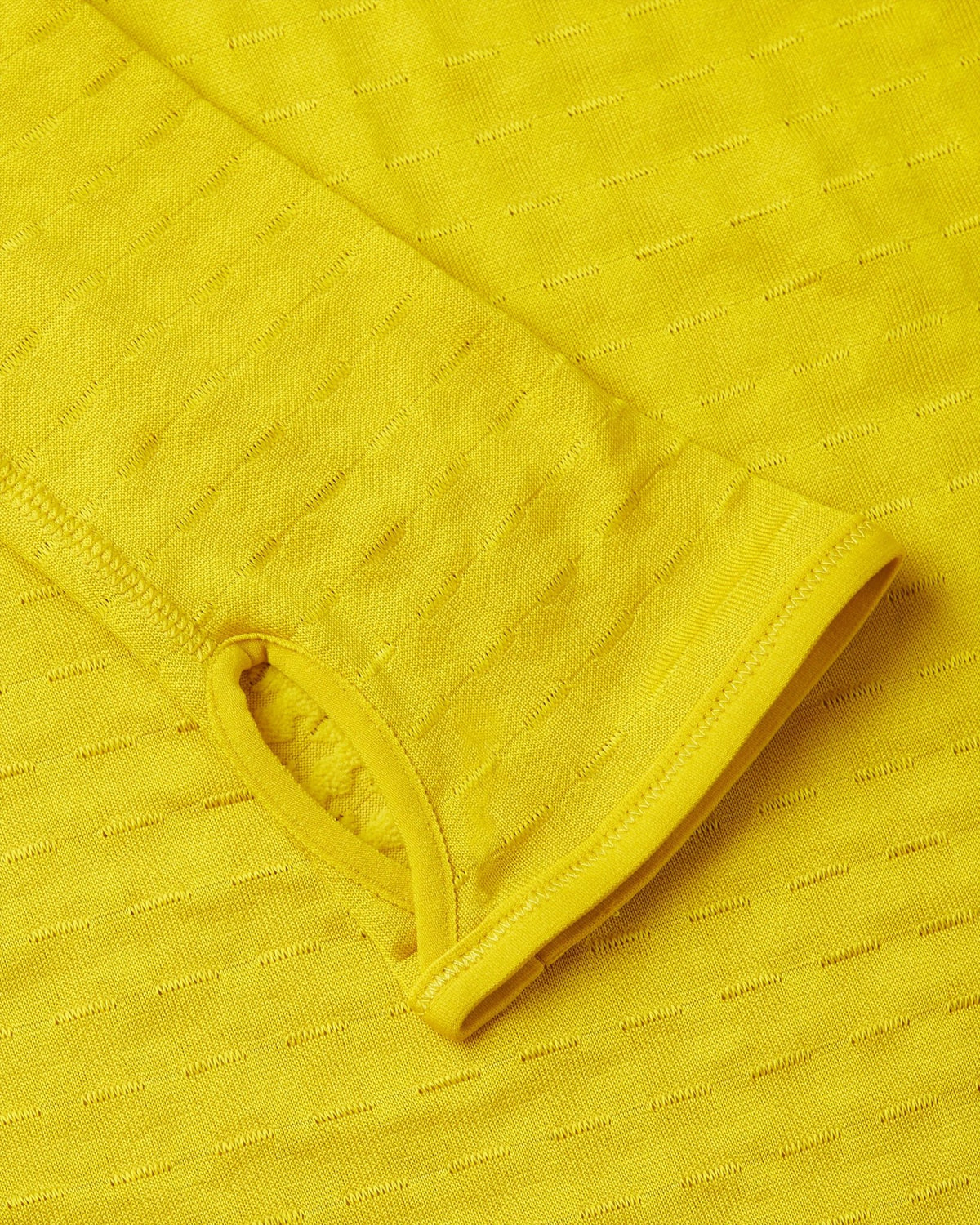 Close-up of the textured yellow sleeve cuff with thumbhole on the Nike x Patta Running Team Half-Zip.