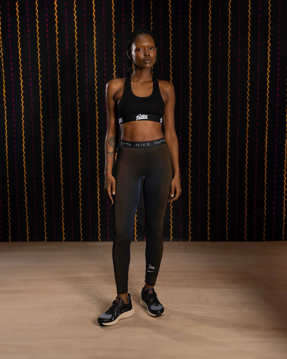 Nike x Patta Running Team leggings in black and deep royal blue worn by a model.