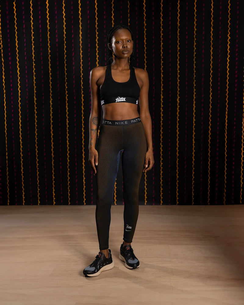 Nike x Patta Running Team leggings in black and deep royal blue worn by a model.