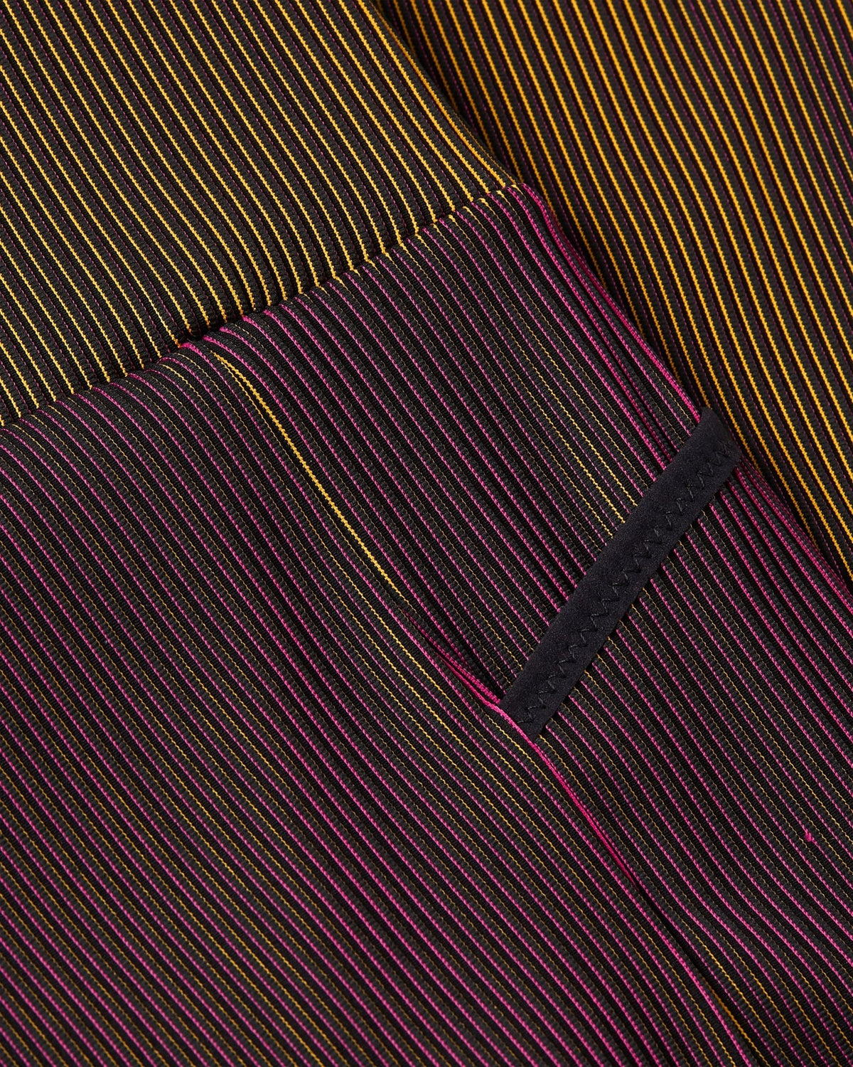 Close-up of Fireberry and Sundial ribbed knit fabric on Nike x Patta Running Team leggings.