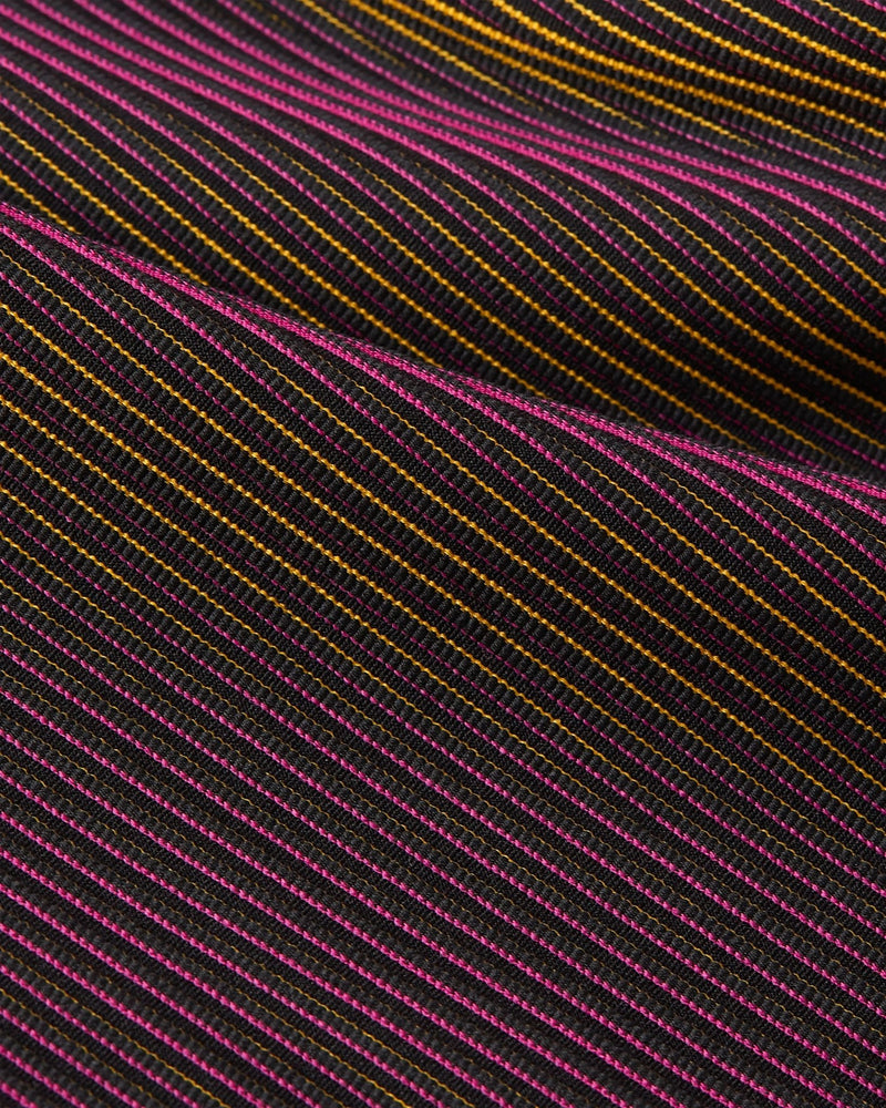 Close-up of the striped Fireberry and Sundial knit texture on the Nike x Patta Running Team leggings.