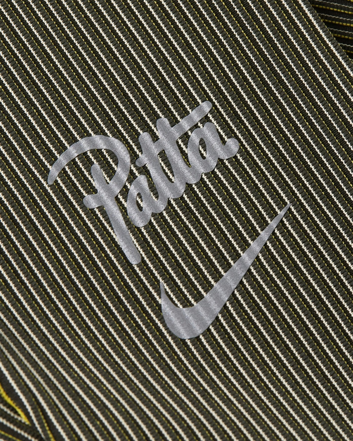 Reflective Nike and Patta script logo on ribbed Saffron Quartz running leggings.