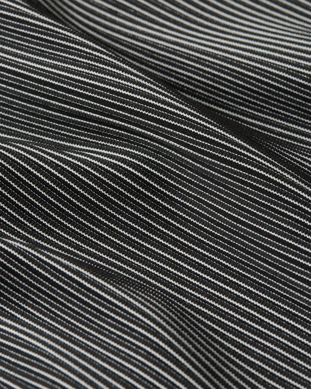 Close-up of the black and grey textured striped fabric of the Nike x Patta Running Team Race Suit.
