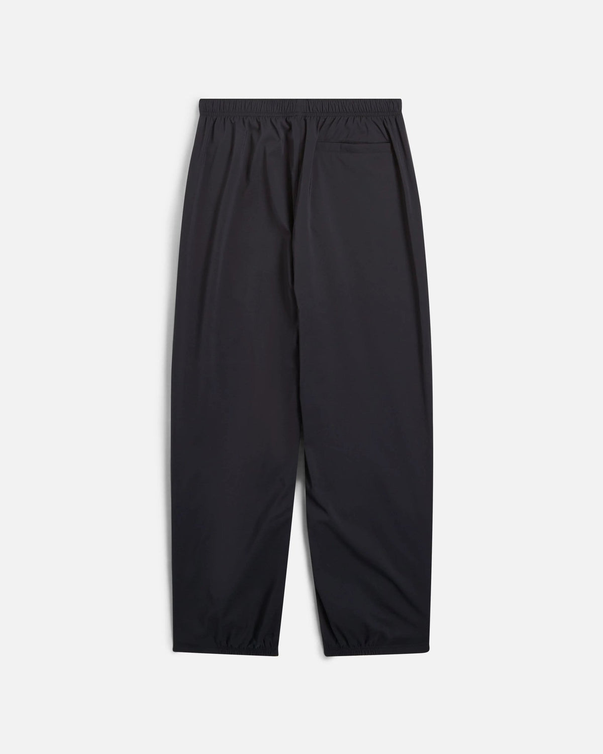 Back view of black Nike x Patta Running Team track pants with an elastic waistband and back pocket.