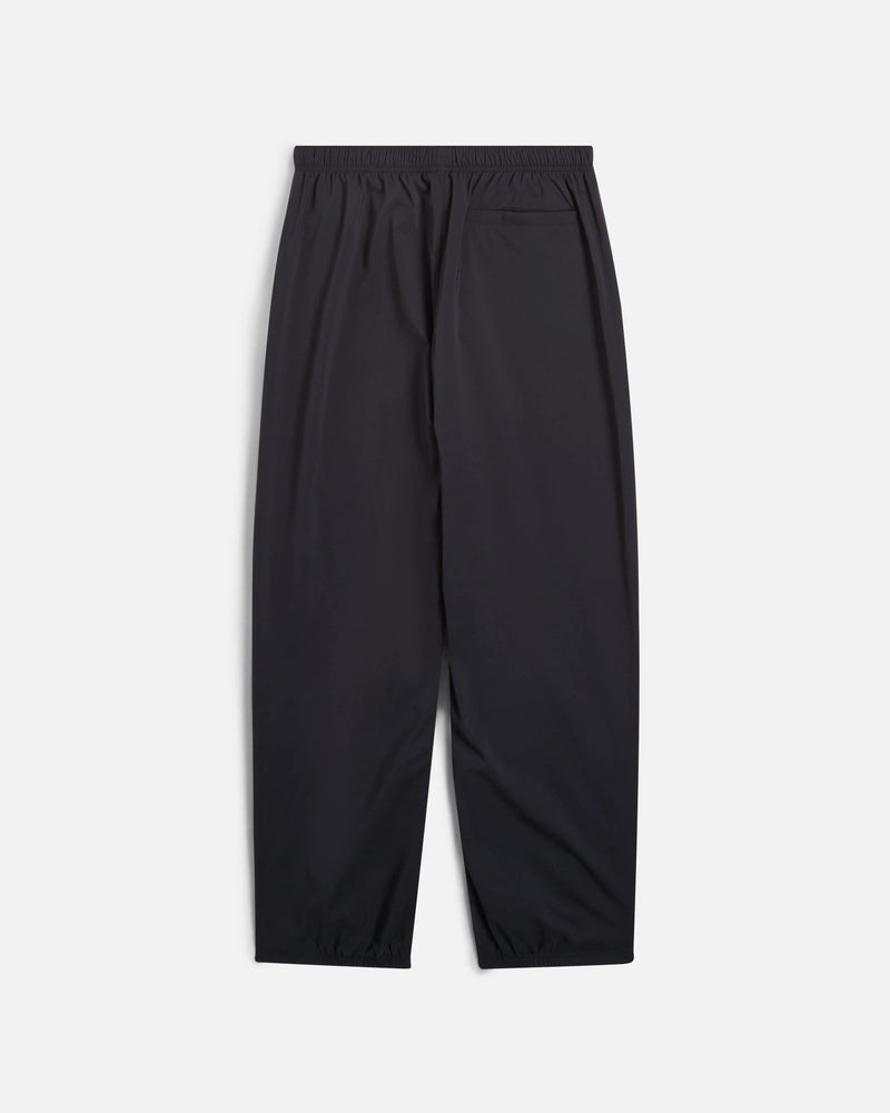 Back view of black Nike x Patta Running Team track pants with an elastic waistband and back pocket.