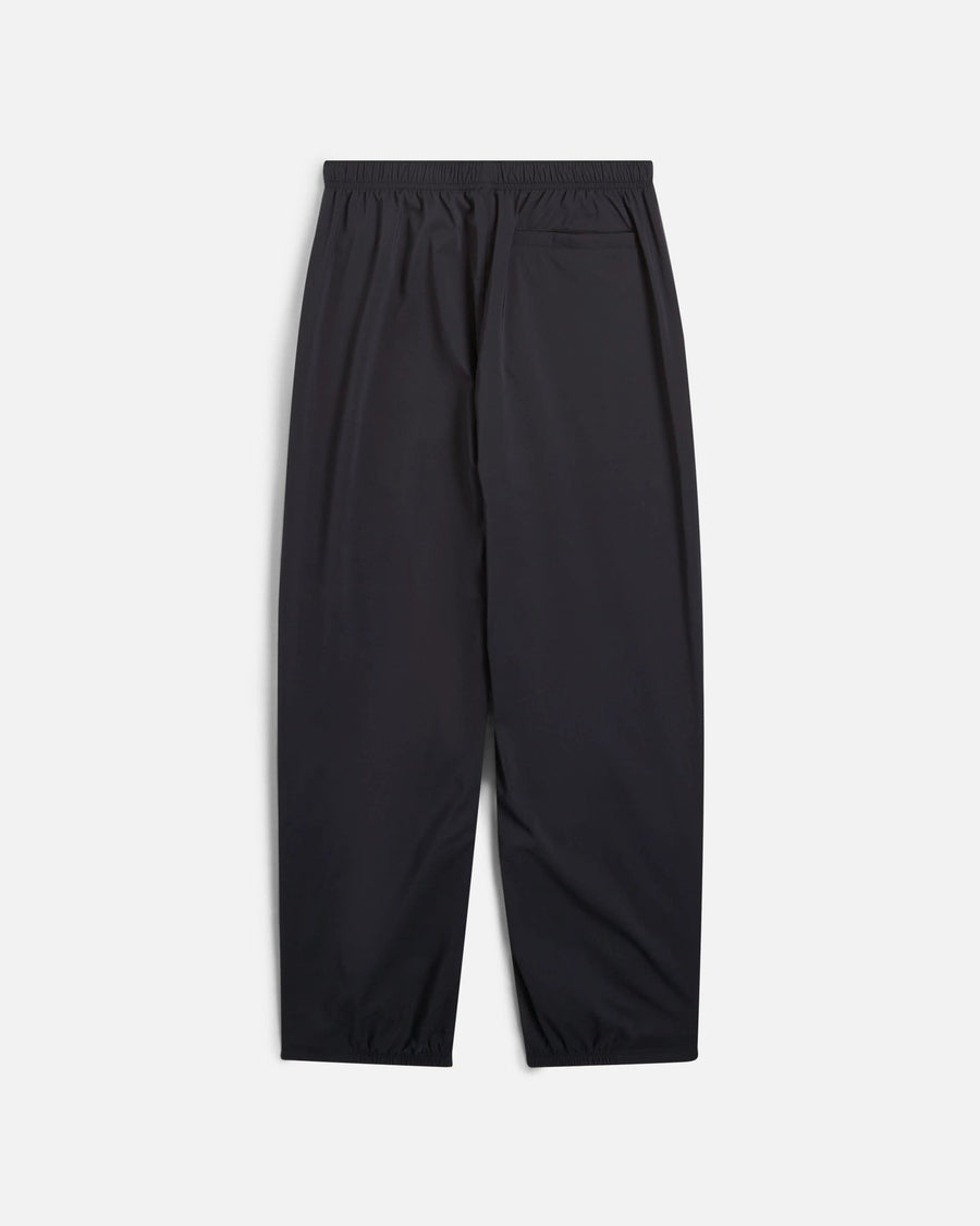 Back view of black Nike x Patta Running Team track pants with an elastic waistband and back pocket.