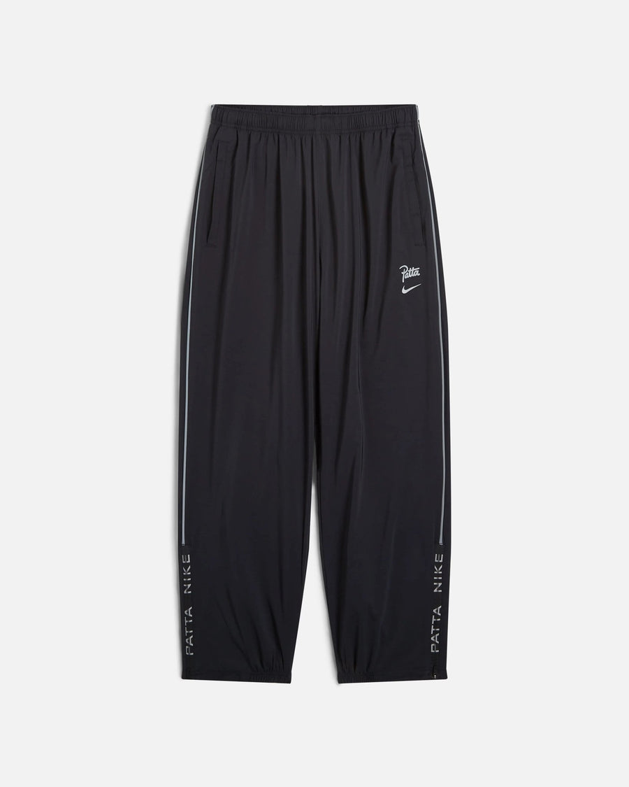 Front view of black Nike x Patta Running Team track pants with reflective side piping.
