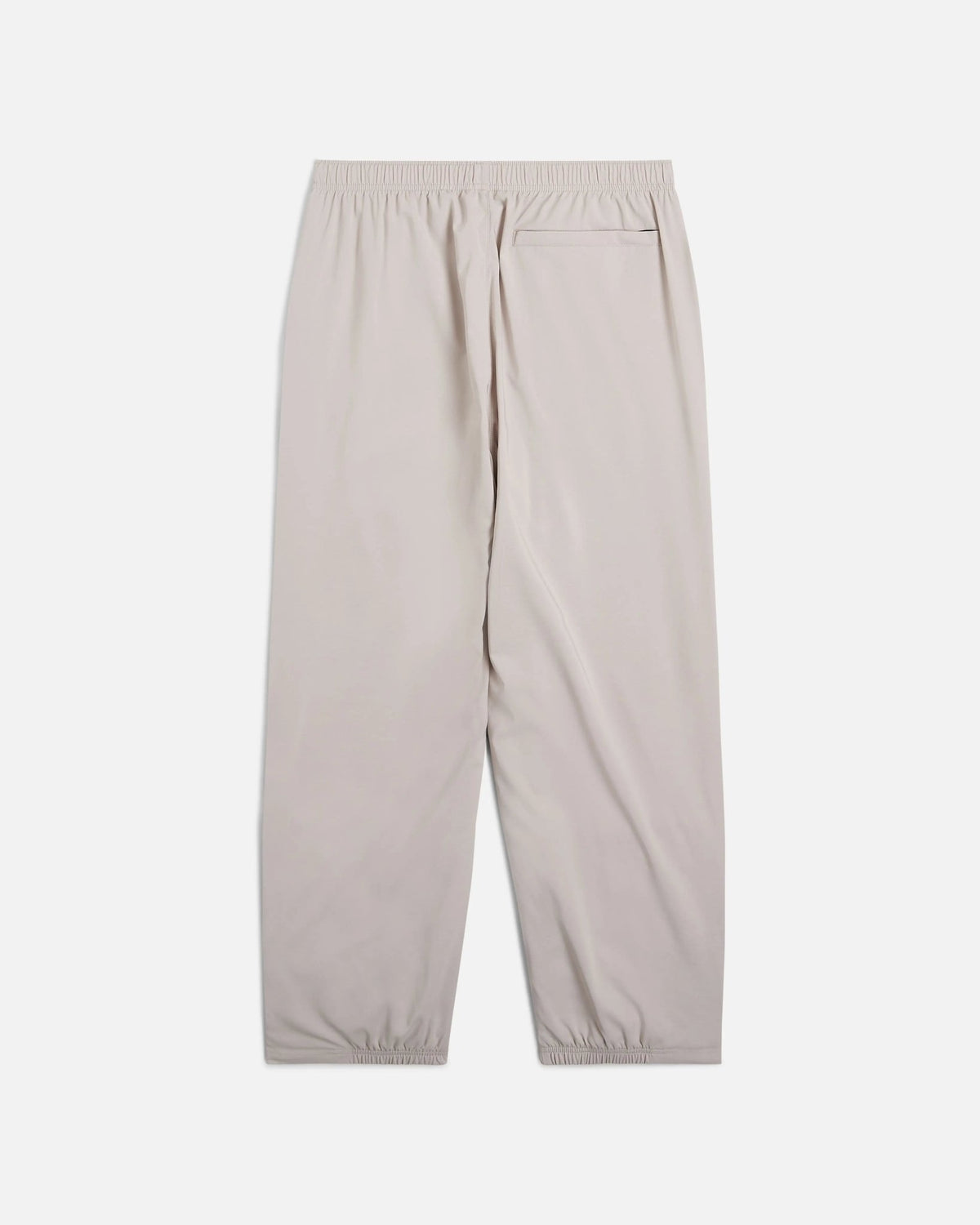 Back view of Nike x Patta Running Team track pants in Sanddrift cream with rear pocket and elastic waistband.