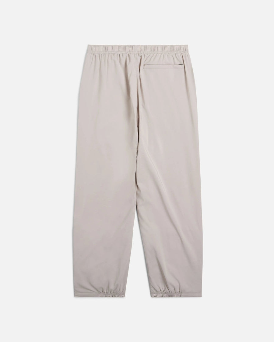 Back view of Nike x Patta Running Team track pants in Sanddrift cream with rear pocket and elastic waistband.