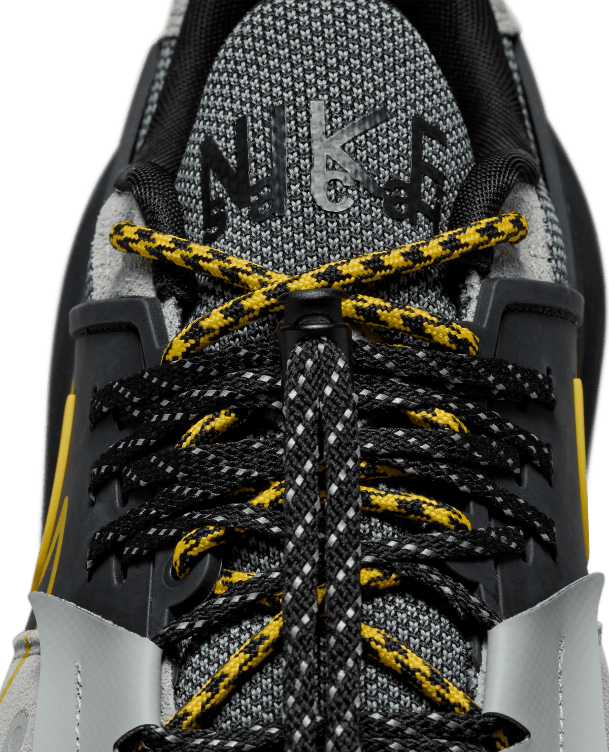 Close-up of Nike Zegamadome x Sacai sneaker tongue and double laces in matte silver, black, and tour yellow.