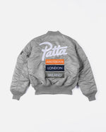 Back view of the Patta x Alpha Industries MA-1 Celebration jacket in silver featuring embroidered city patches.