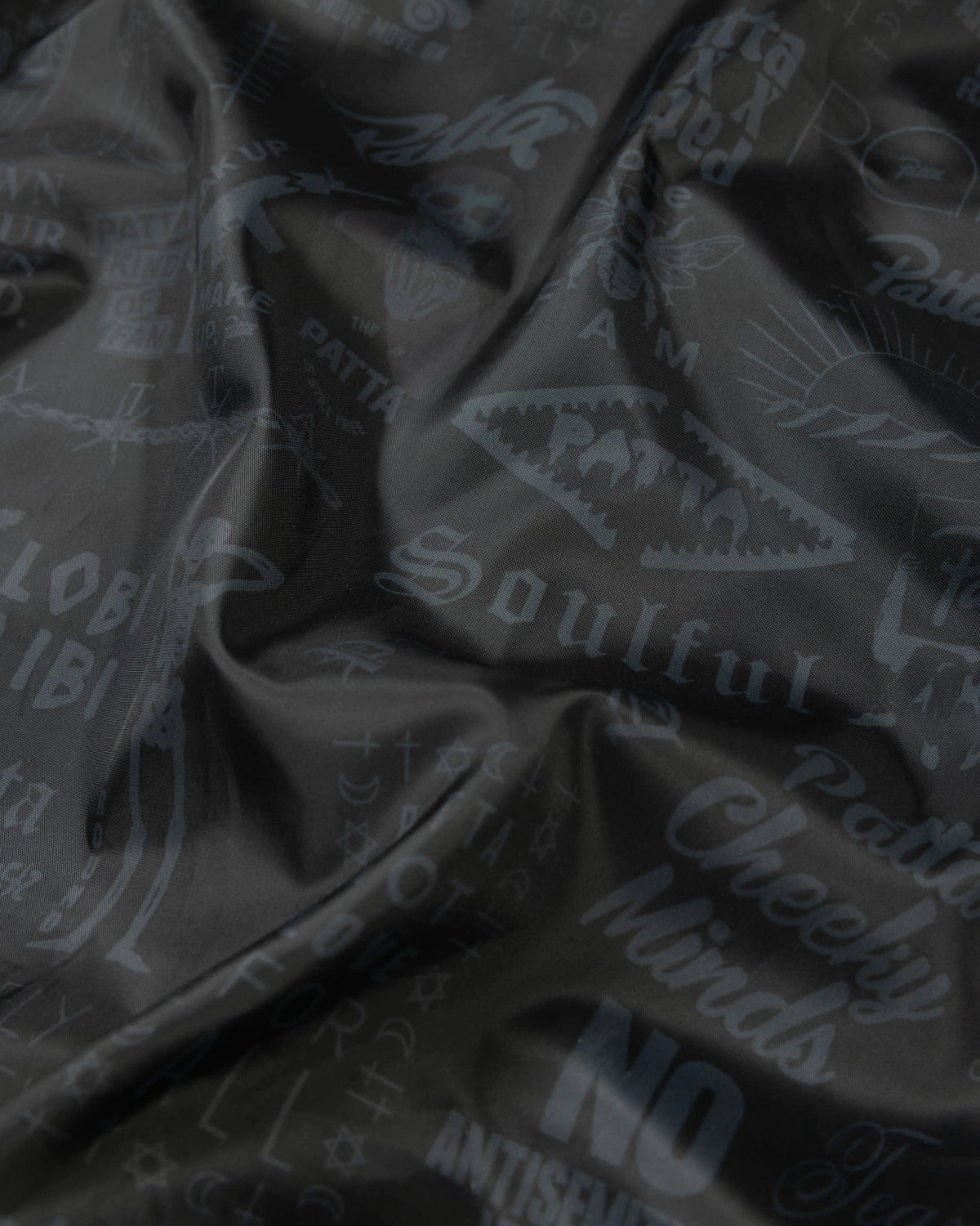 Black printed inner lining of the Patta x Avirex Icon Jacket with tonal archival graphics.