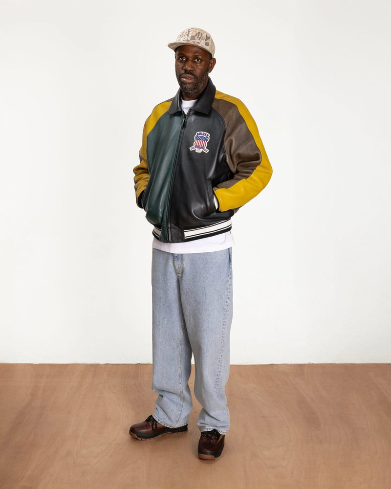 Model wearing the multicolor Patta x Avirex Icon leather jacket in a studio setting.