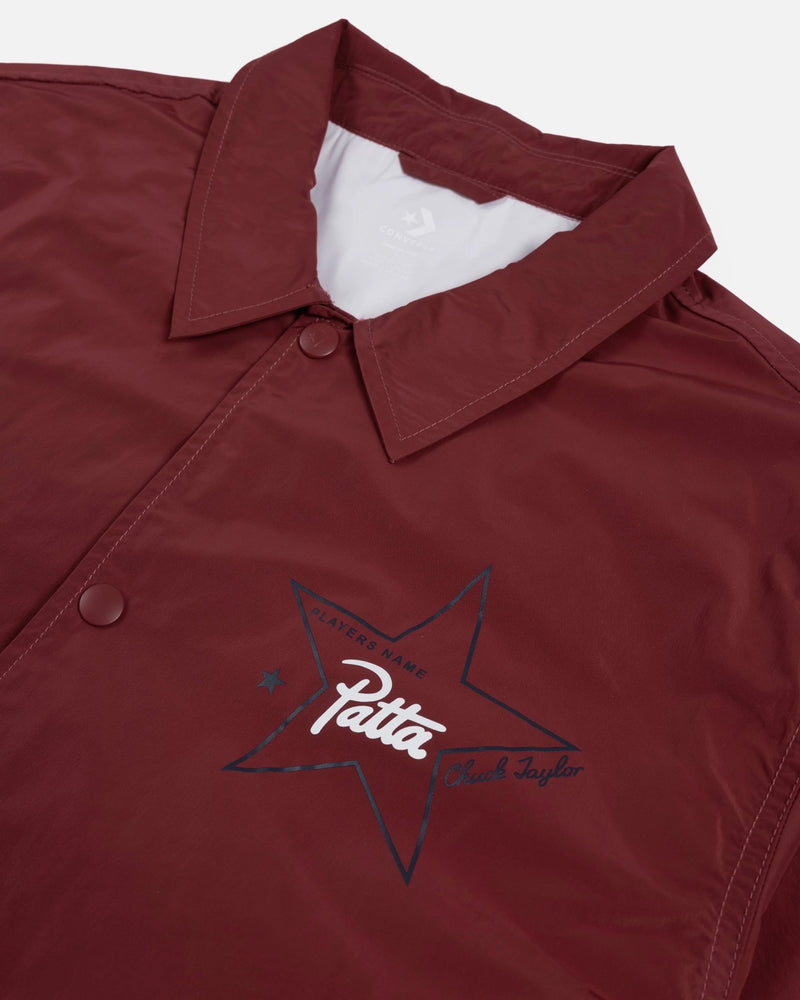 Close-up of garnet Patta x Converse coaches jacket showing collar, snap buttons, and printed chest star logo.