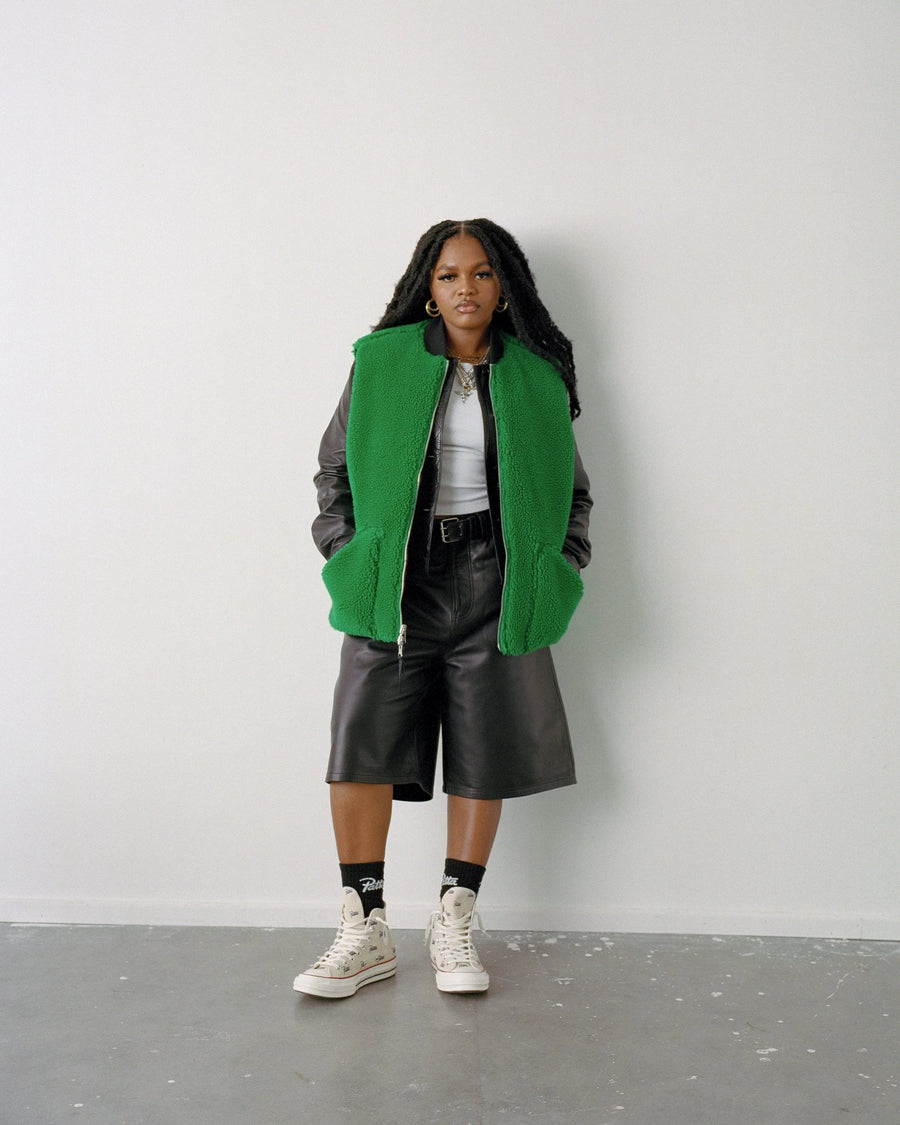 Model wears the Jolly Green Patta x Converse Reversible Vest styled with leather shorts.