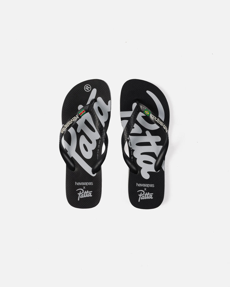 Top view of black Patta x Havaianas rubber flip-flops featuring bold white script logo graphics.