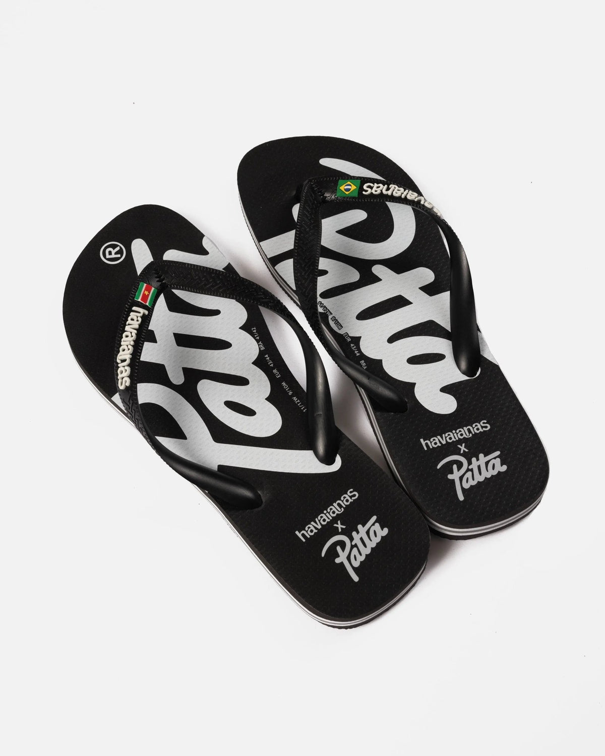 Patta x Havaianas black flip-flops with bold white logo branding across rubber footbeds.