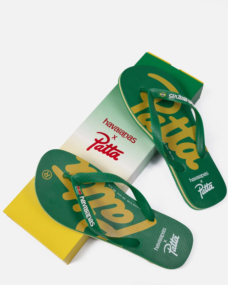 Patta x Havaianas green rubber flip-flops with yellow script branding resting on co-branded box.