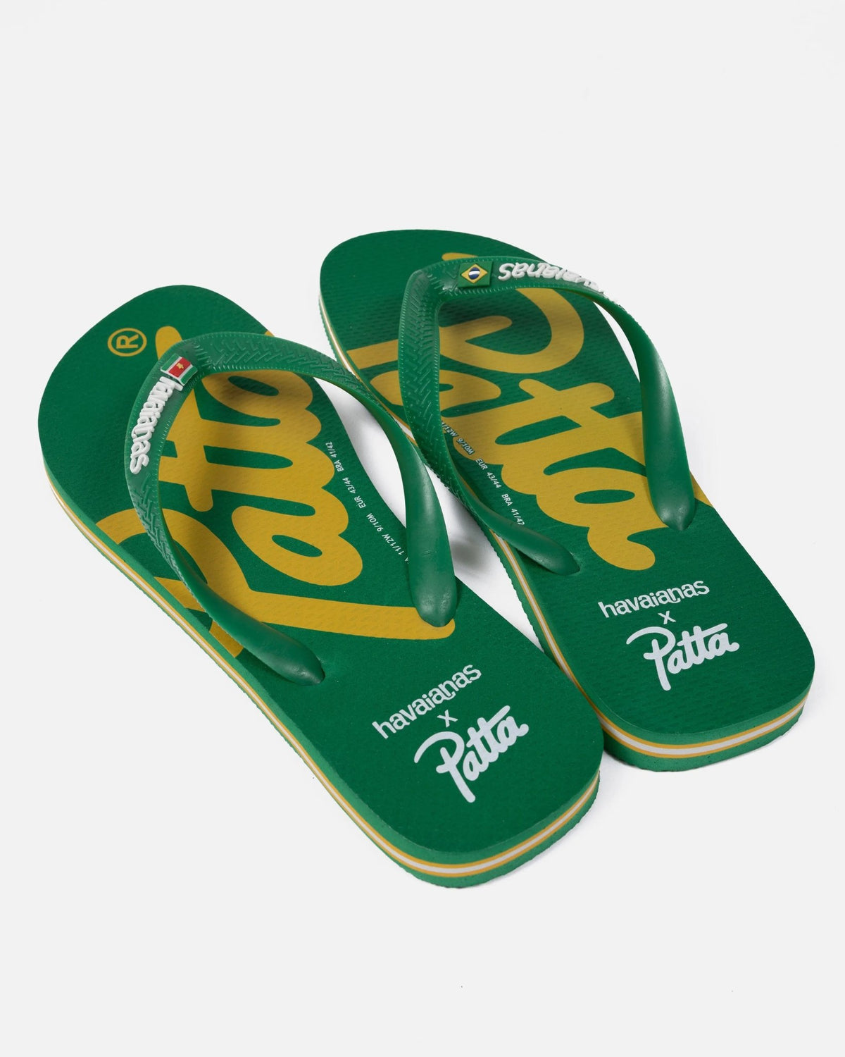 Green Patta x Havaianas flip-flops featuring yellow logo script on the footbeds and rubber straps.